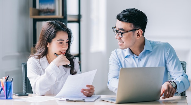 Two Asian businesspeople working at office