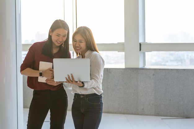 two Asian Businesswomen working with laptop In the modern creative Office