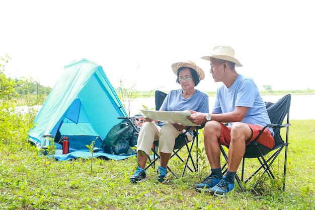 Two Asian elderly couples take a nature tour Camping and enjoying the beautiful natural scenery The concept of natural tourism in retirement age