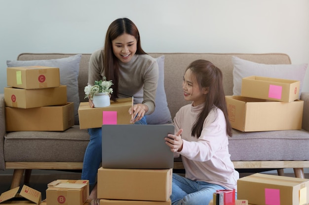 Two Asian SME business woman working at home office online shopping concept