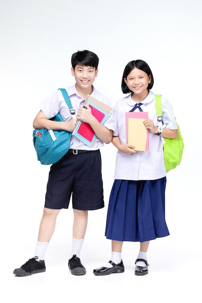 Two asian smiling school kids with colorful stationery,