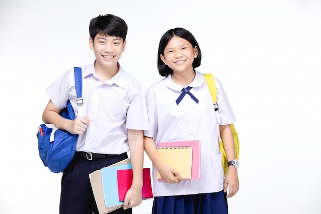 Two asian smiling school kids with colorful stationery,