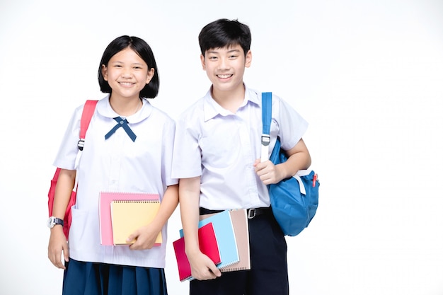 Two asian smiling school kids with colorful stationery,