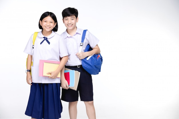 Two asian smiling school kids with colorful stationery,