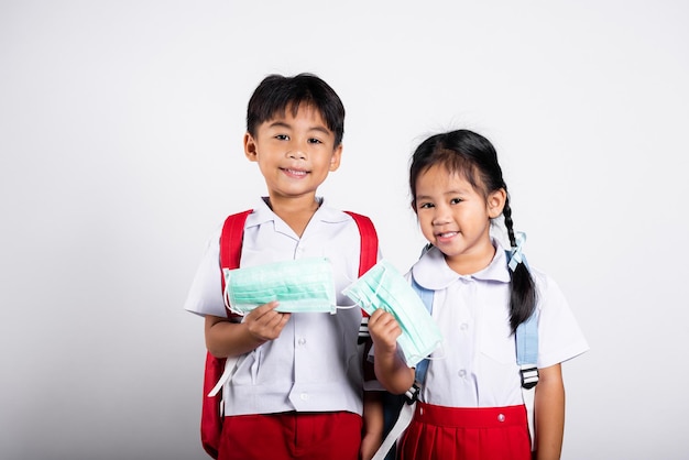 Two Asian student kid girl boy brother sister holding protect mask ready to go to school