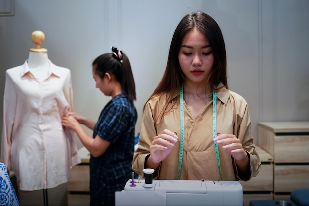 Two asian women Sewing and selling clothes online online business idea