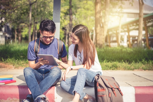 Two Asian young college people discussing about homework and final examination for testing