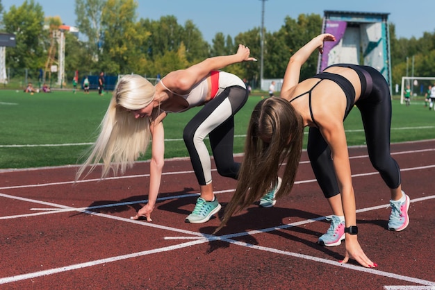 Two athlete young woman runnner at the stadium outdoors