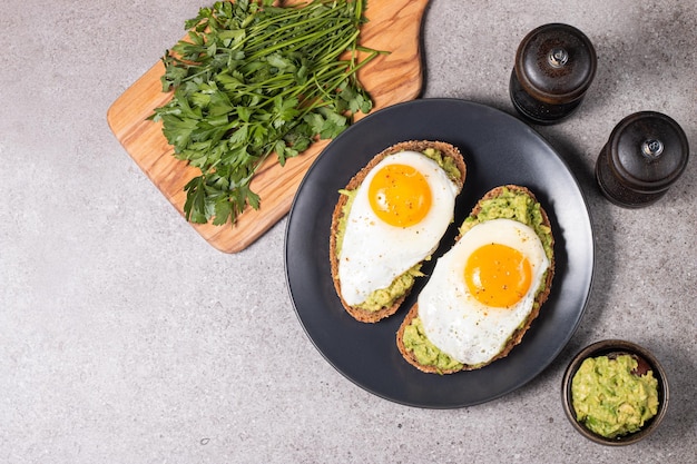 Two avocado open sandwiches with egg. Keto and diet concept. Healthy toast food for breakfast.