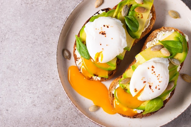 Two avocado open sandwiches with egg. Keto and diet concept. Healthy toast food for breakfast.