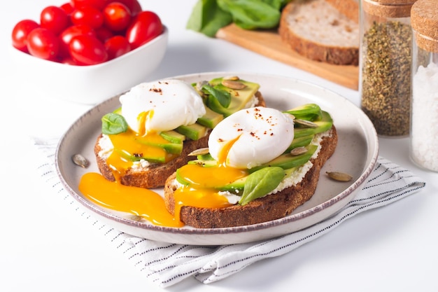 Two avocado open sandwiches with egg. Keto and diet concept. Healthy toast food for breakfast.