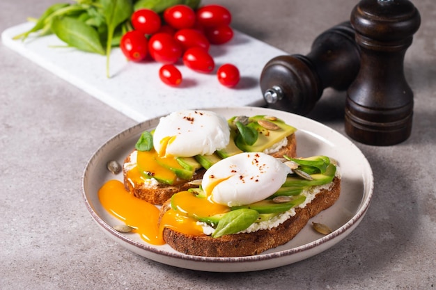 Two avocado open sandwiches with egg. Keto and diet concept. Healthy toast food for breakfast.