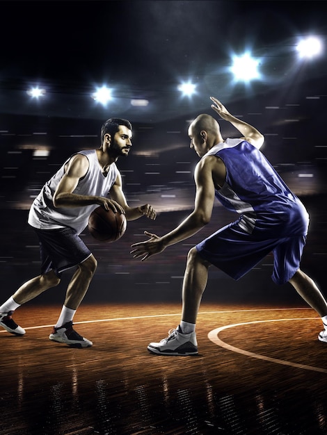 Two basketball players in action in gym in lights