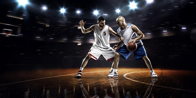 Two basketball players in action in gym panorama view