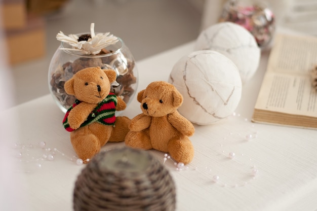 Two bear cubs are sitting on the background of a festive decor