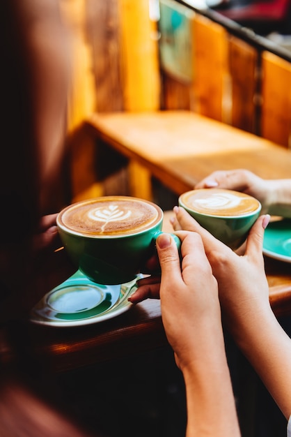 Two beautiful woman keeping cups of coffee.