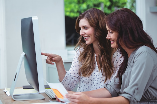 Two beautiful woman using computer