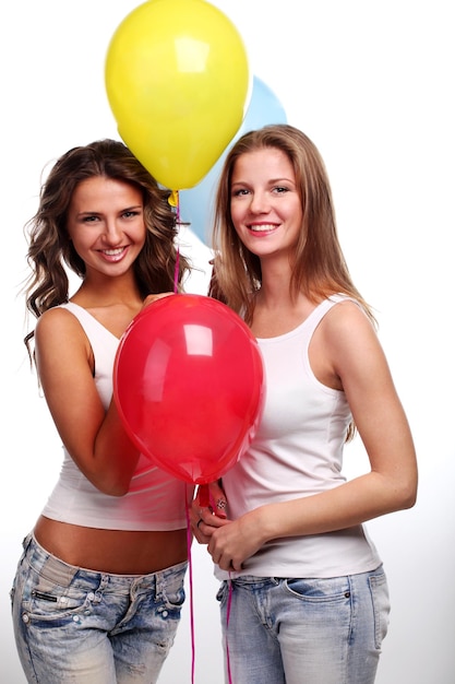 Two beautiful young girlfriends with color balloons