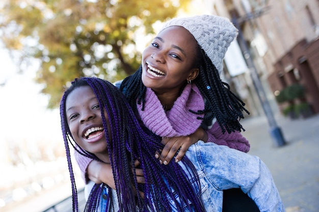 Two beautiful young woman looking at camera in the street.