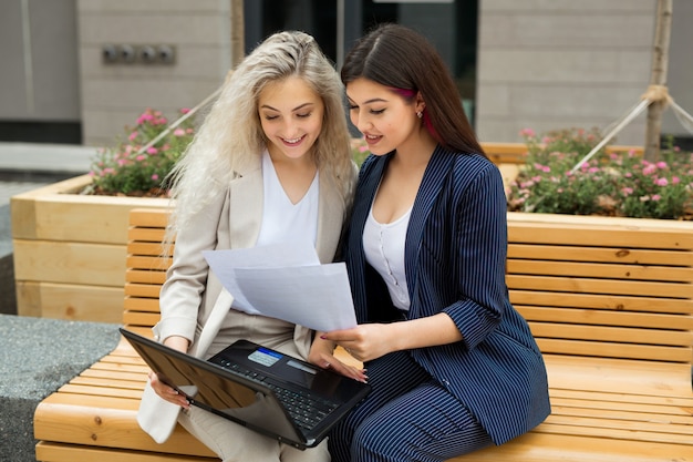 two beautiful young women in suits with laptop