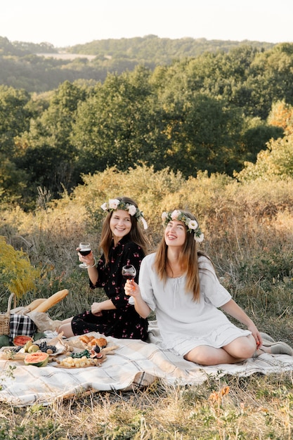 Two best friends on picnic in the field laying on the laid smiling