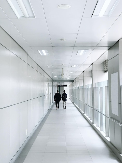 Two Best Friends Walk Through Station Hallway During The Day