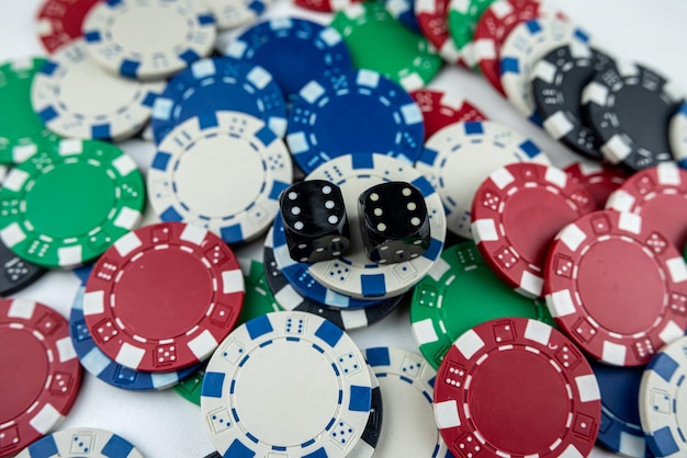 Two black dice on poker chips top view Casino concept