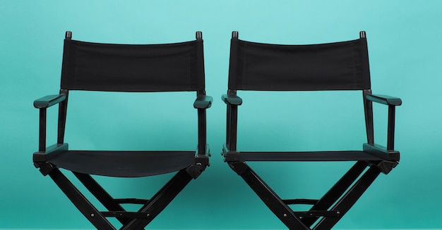 Two Black director chair on green or Tiffany Blue or mint background.it use in videography or film cinema industry