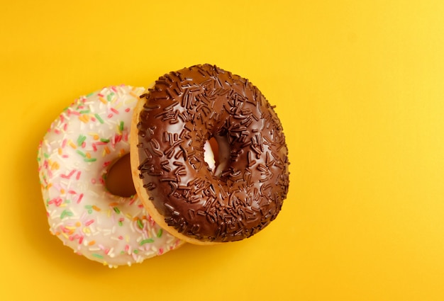 Two black and white donuts on yellow 