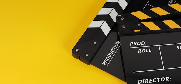 Two Black and yellow Clapper board or movie slate.it use in video production ,film, cinema industry on yellow background.