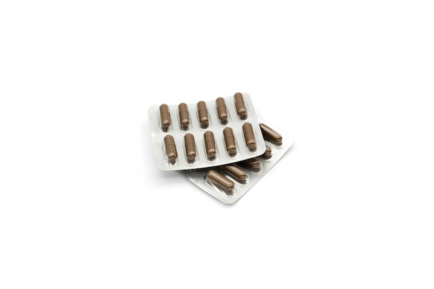 Two blister packs with brown capsules isolated on a white background