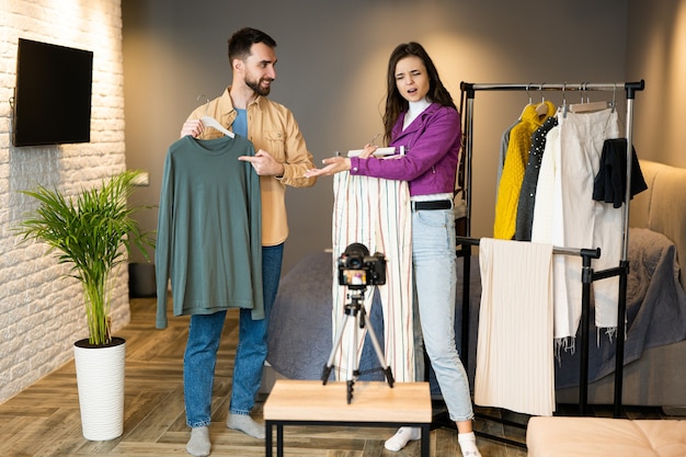 Two bloggers influencers are showing clothes for their followers to sell it on store online streaming