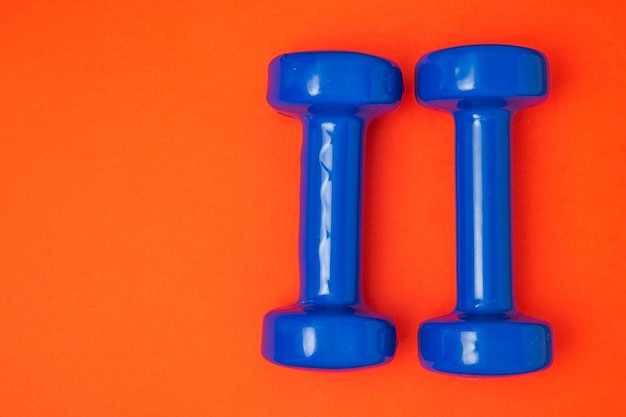 Two blue of dumbbells Isolated on red background