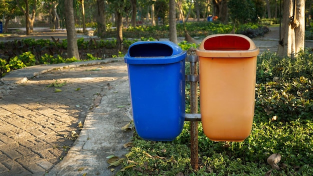 two blue and orange trash cans used to accommodate organic and nonorganic waste from city parks