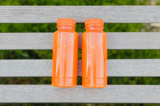 Two bottles of freshly squeezed orange or carrot juice