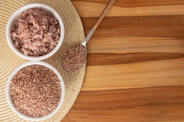 Two bowls filled with raw and cooked organic rice food