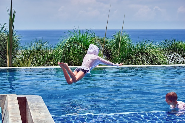 Two boys playing and swimming in the outdoor pool copy space