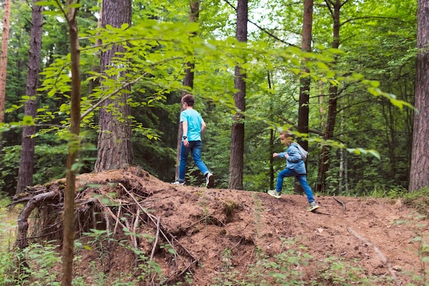 two boys running in the woods