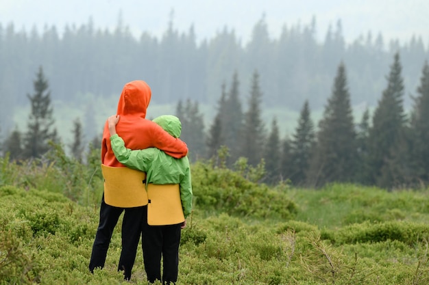 Two boys of school age are hugging and admiring the view of the Carpathians