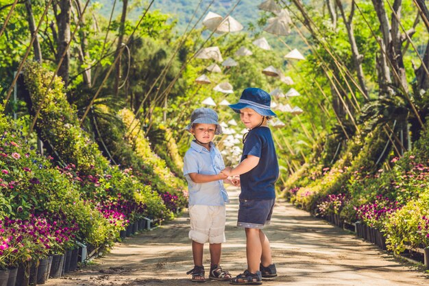 Two boys, a traveler in Vietnam against the backdrop of Vietnamese hats