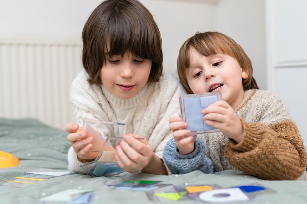 Two brothers playing development smart game at home Siblings spending time together resolving logical toy