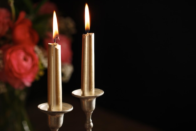 Two burning candles on dark background Traditional Jewish Shabbat ritual Shabbat Shalom