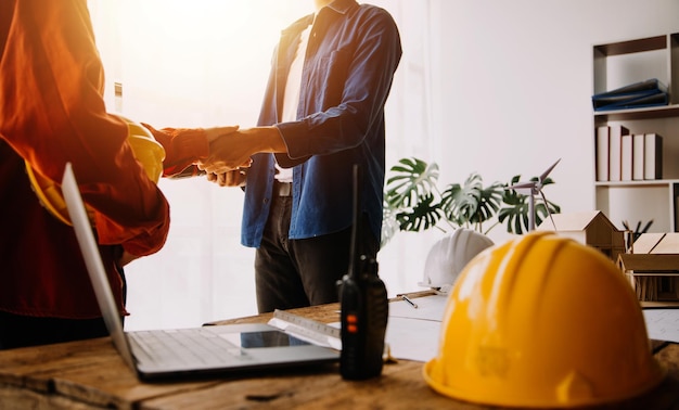 Two business man construction site engineer Engineering objects on workplace with partners interacting on background