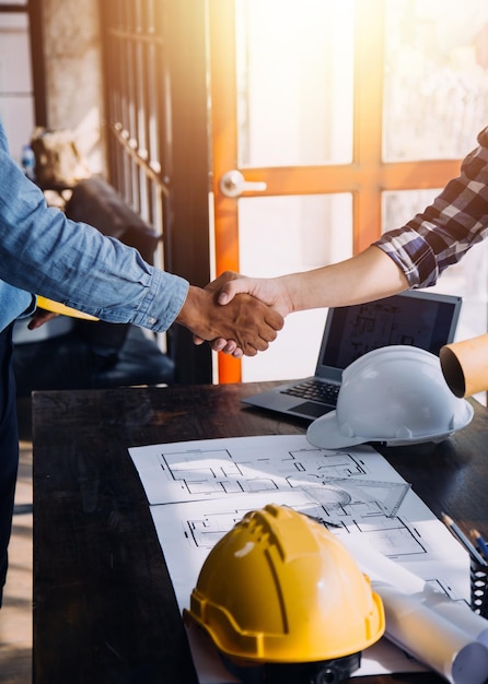 Two business man construction site engineer Engineering objects on workplace with partners interacting on background