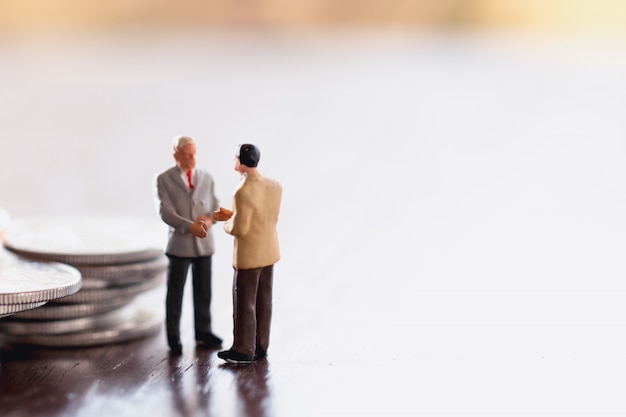 Two Business man,saving,investment and finance concepts. Miniature people Stand