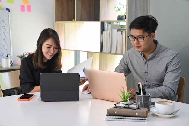 Two business people discussing company financial strategy together in office.