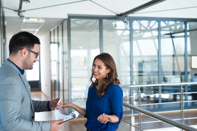 Two business people having conversation in company's corridor.