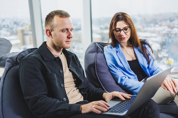 Two business people working remotely online using a laptop Colleagues work remotely in the workspace