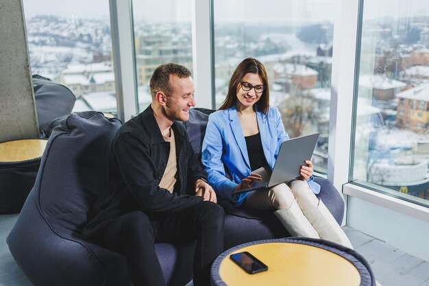 Two business people working remotely online using a laptop Colleagues work remotely in the workspace