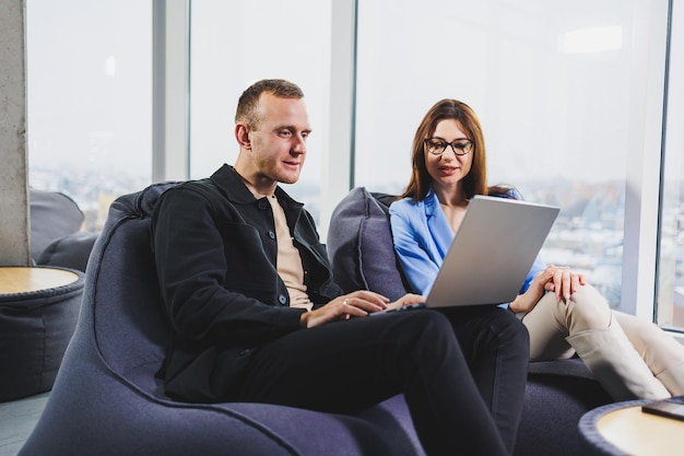 Two business people working remotely online using a laptop Colleagues work remotely in the workspace